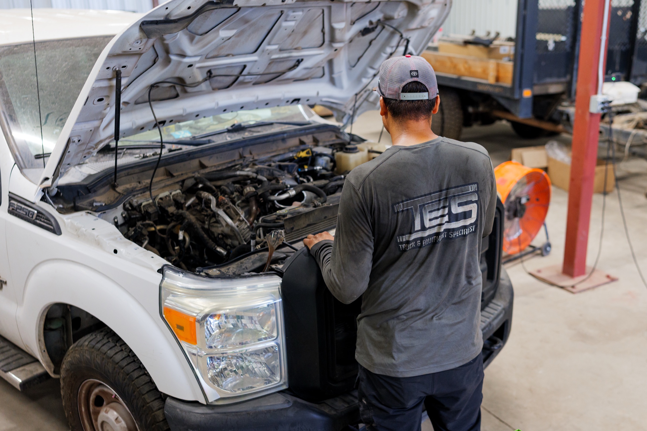 TES technician wrenching over a diesel truck engine in Phoenix